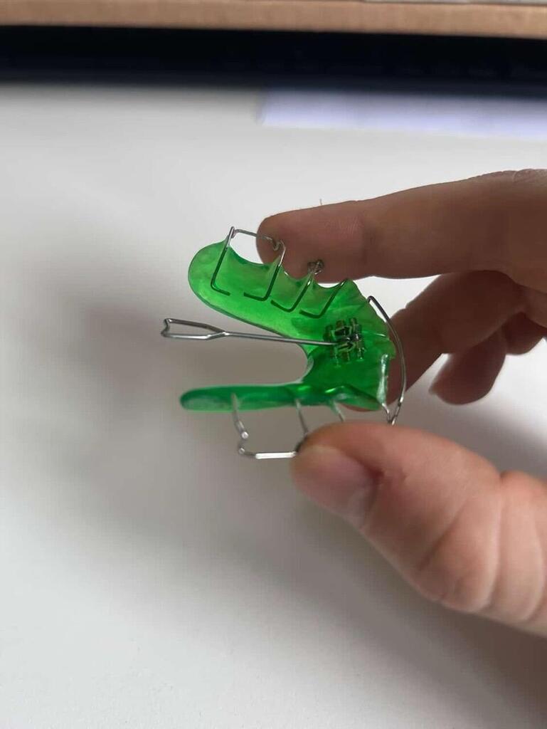 Green appliance held between fingers